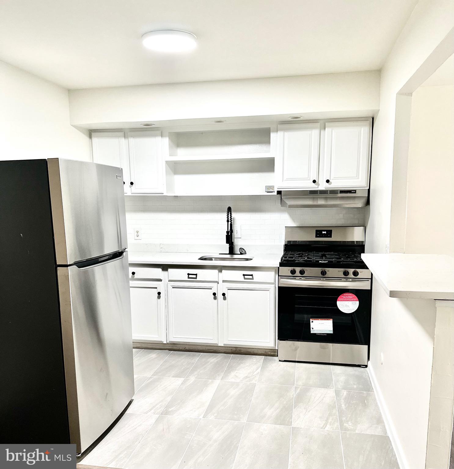 a kitchen with stainless steel appliances granite countertop a refrigerator stove and sink