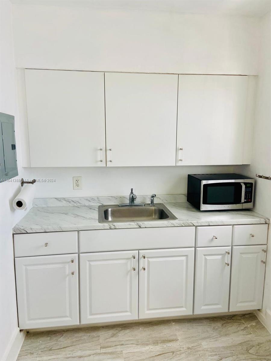 a kitchen with granite countertop white cabinets and a stove