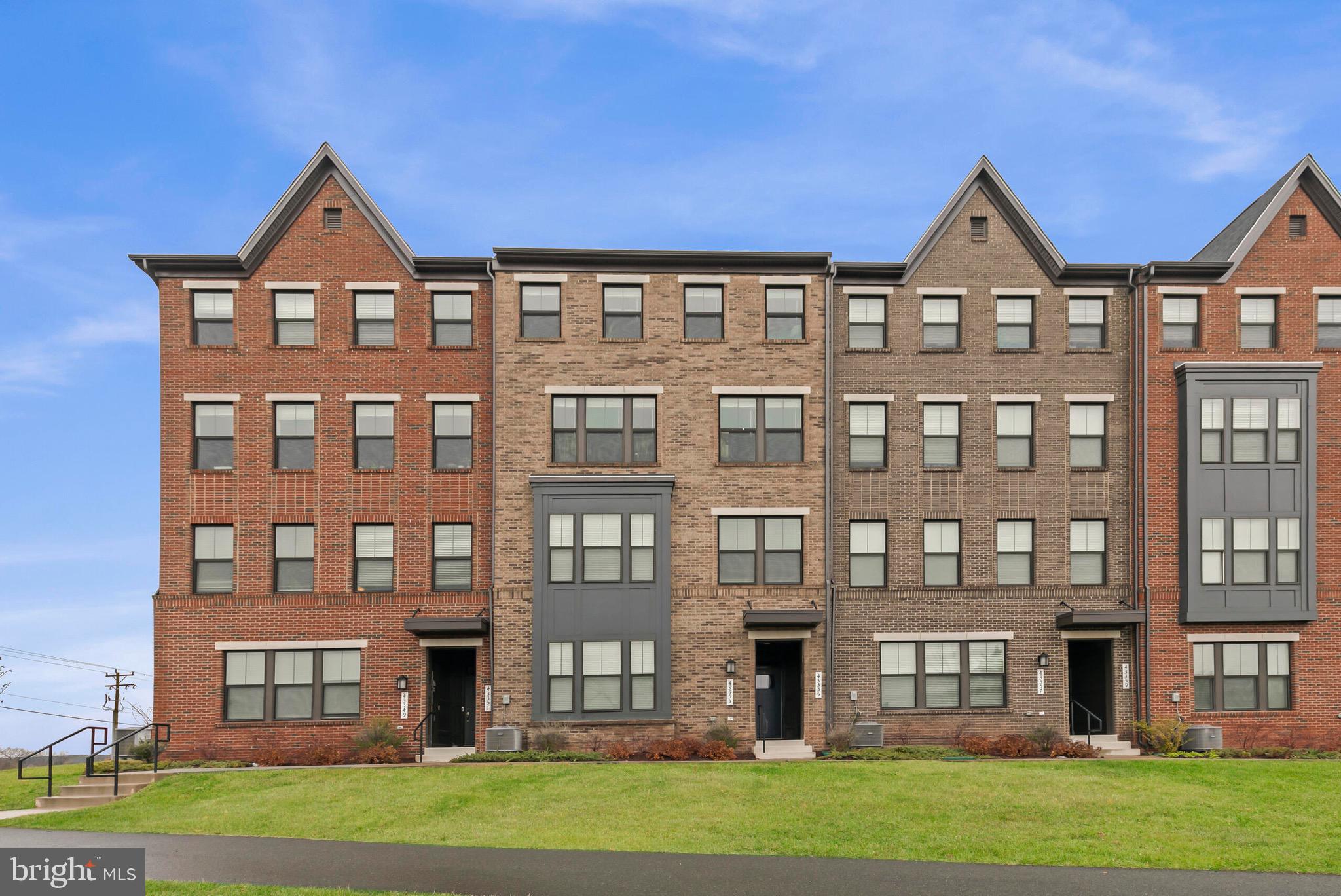 a front view of a residential apartment building with a yard