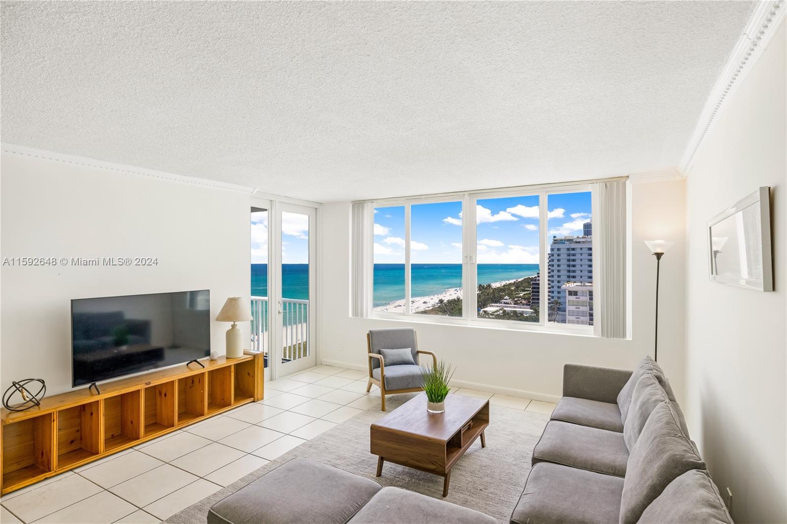 a living room with furniture a flat screen tv and a large window