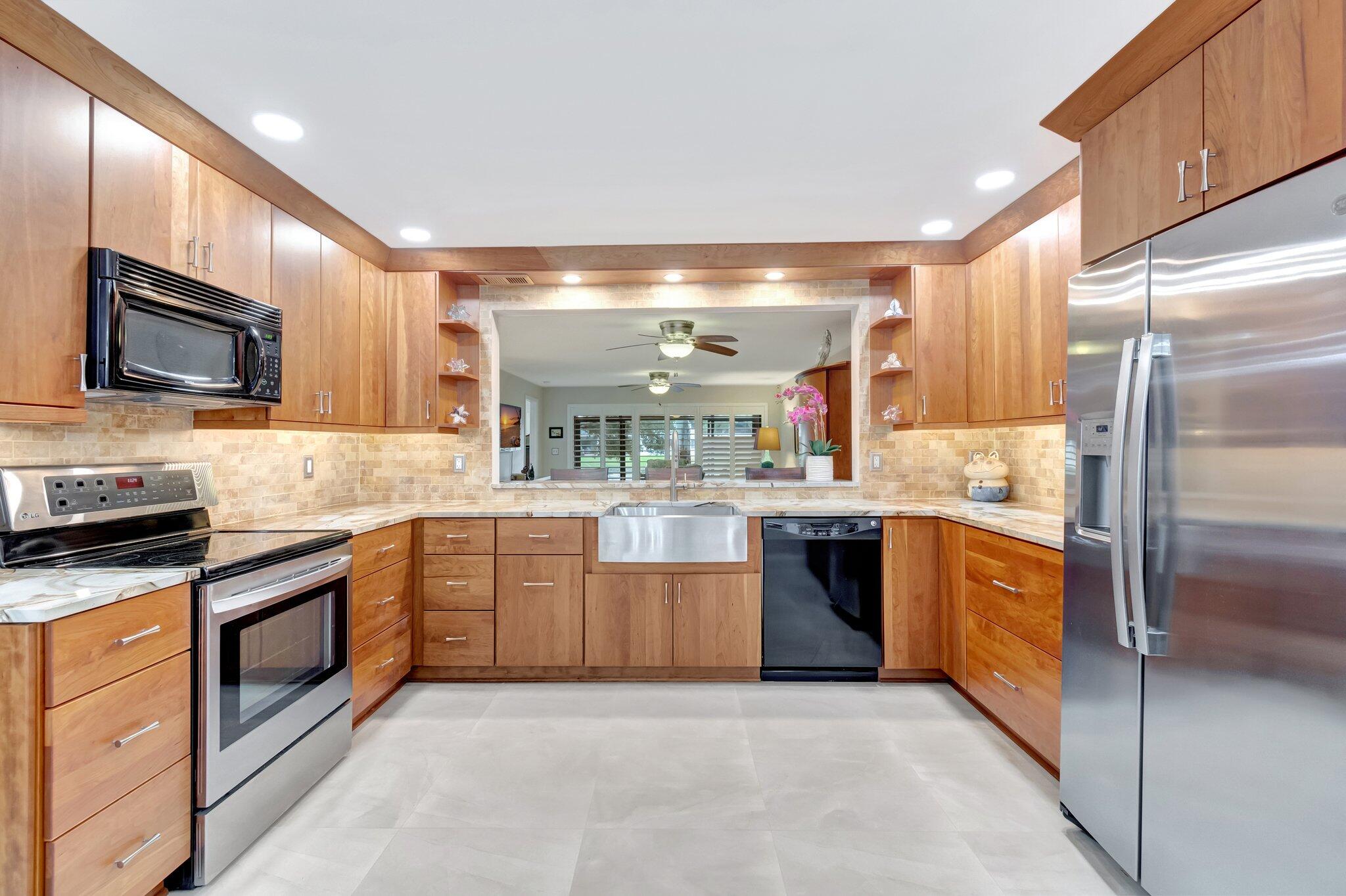 a large kitchen with stainless steel appliances granite countertop a stove a sink dishwasher and a refrigerator