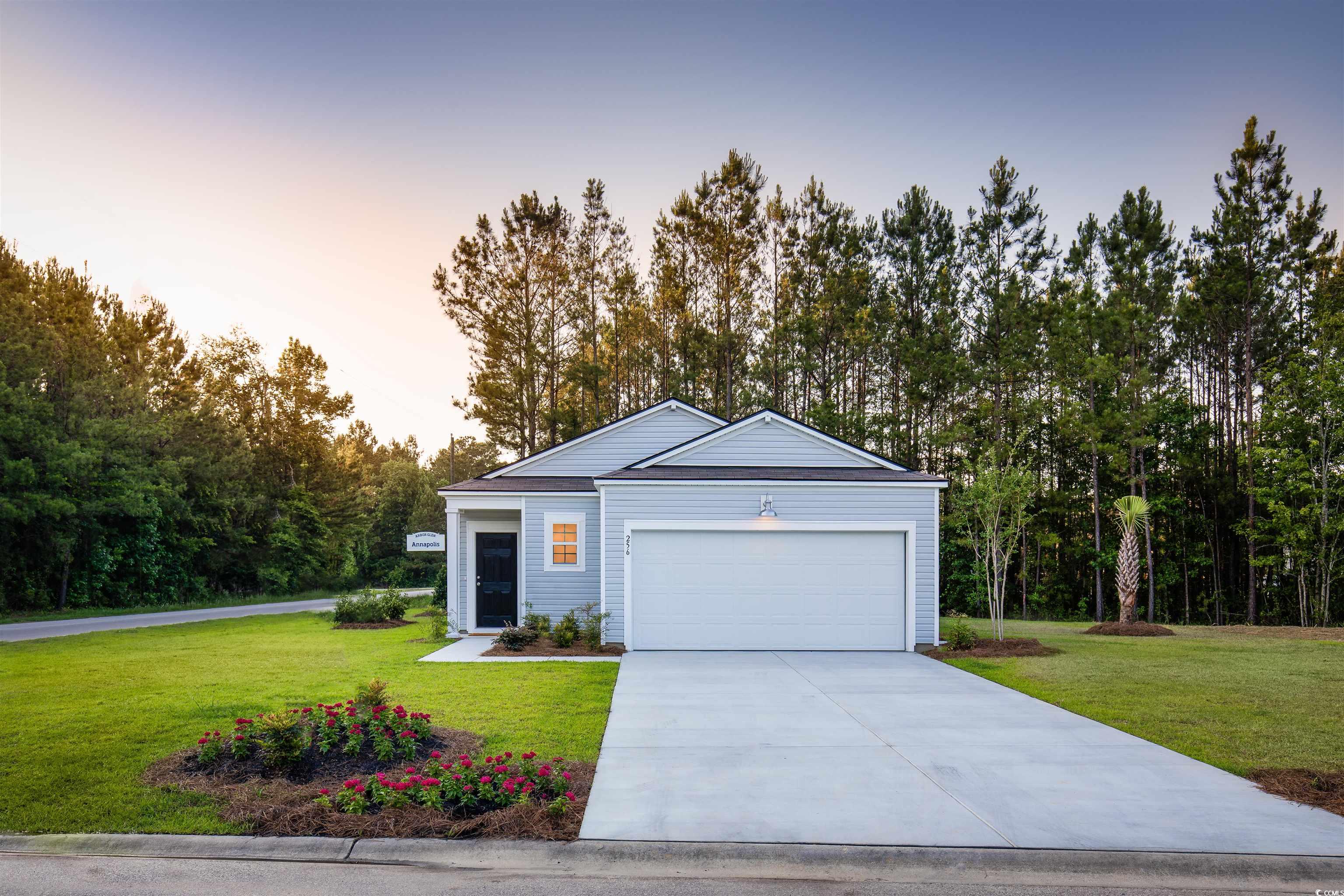 View of front facade with a yard and a garage