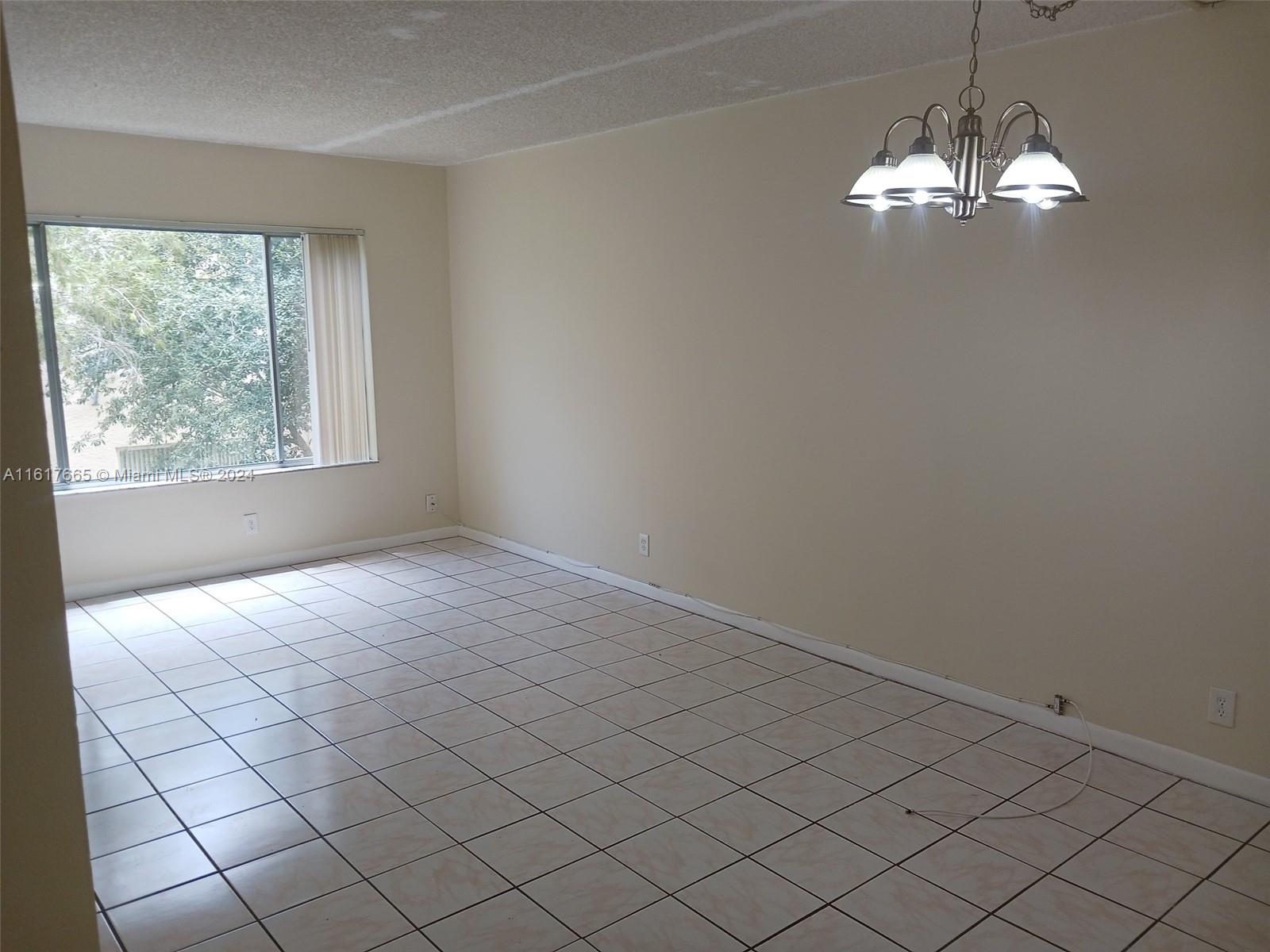 an empty room with windows and chandelier