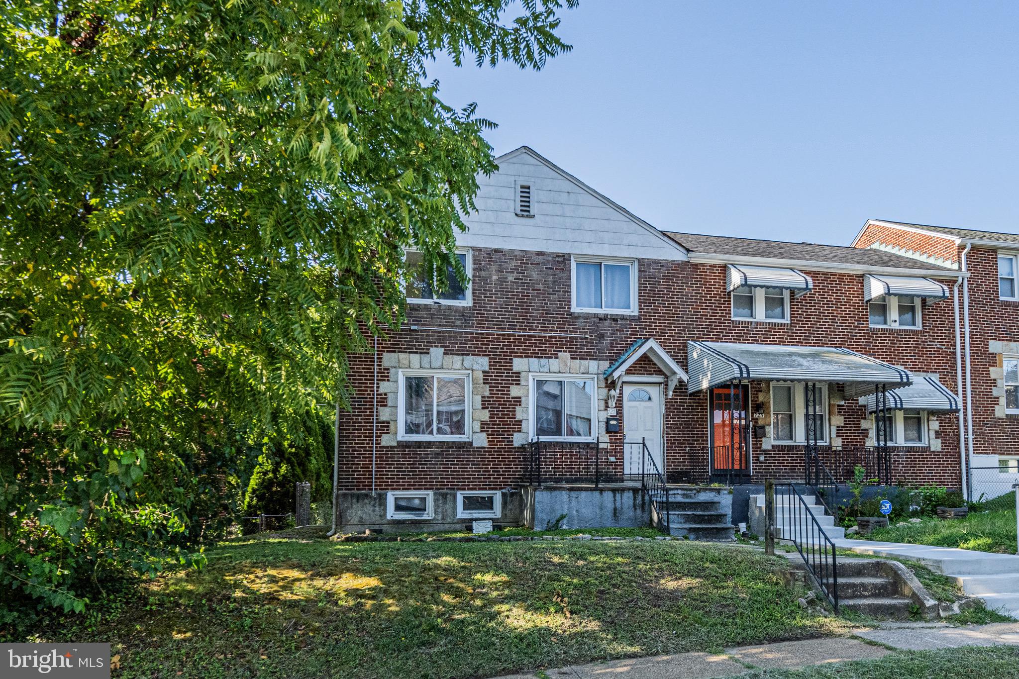 front view of a brick house next to a yard