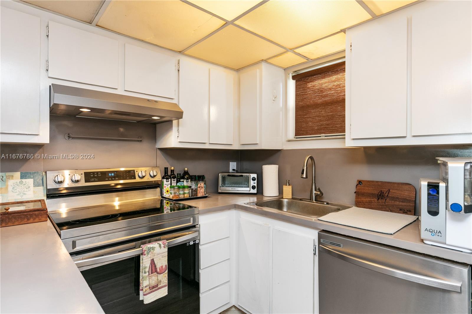 a kitchen with stainless steel appliances granite countertop a stove and a white cabinets