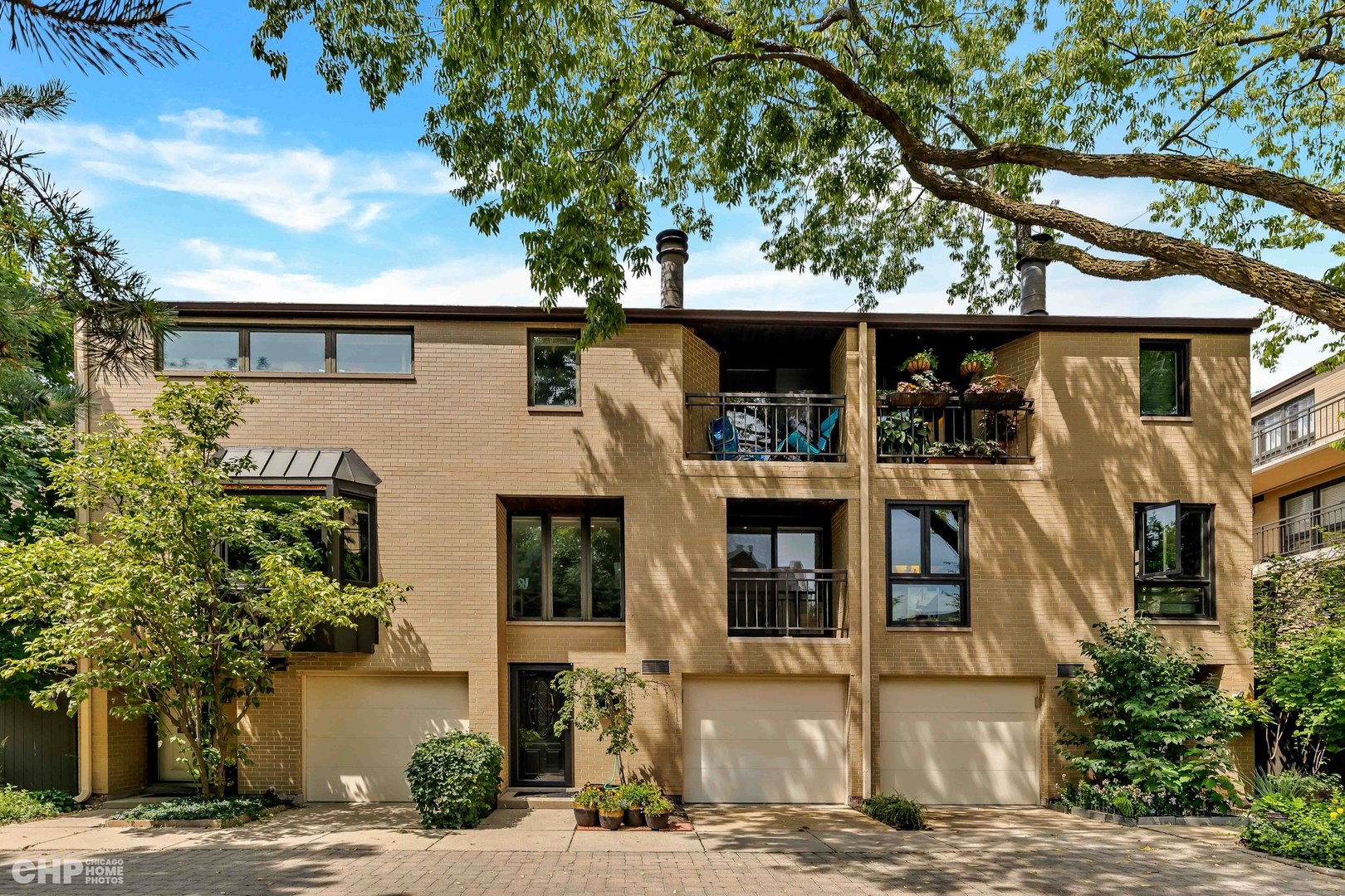 a front view of a house with a tree