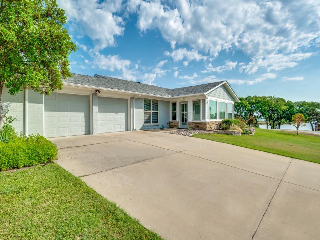 a front view of a house with a yard and trees