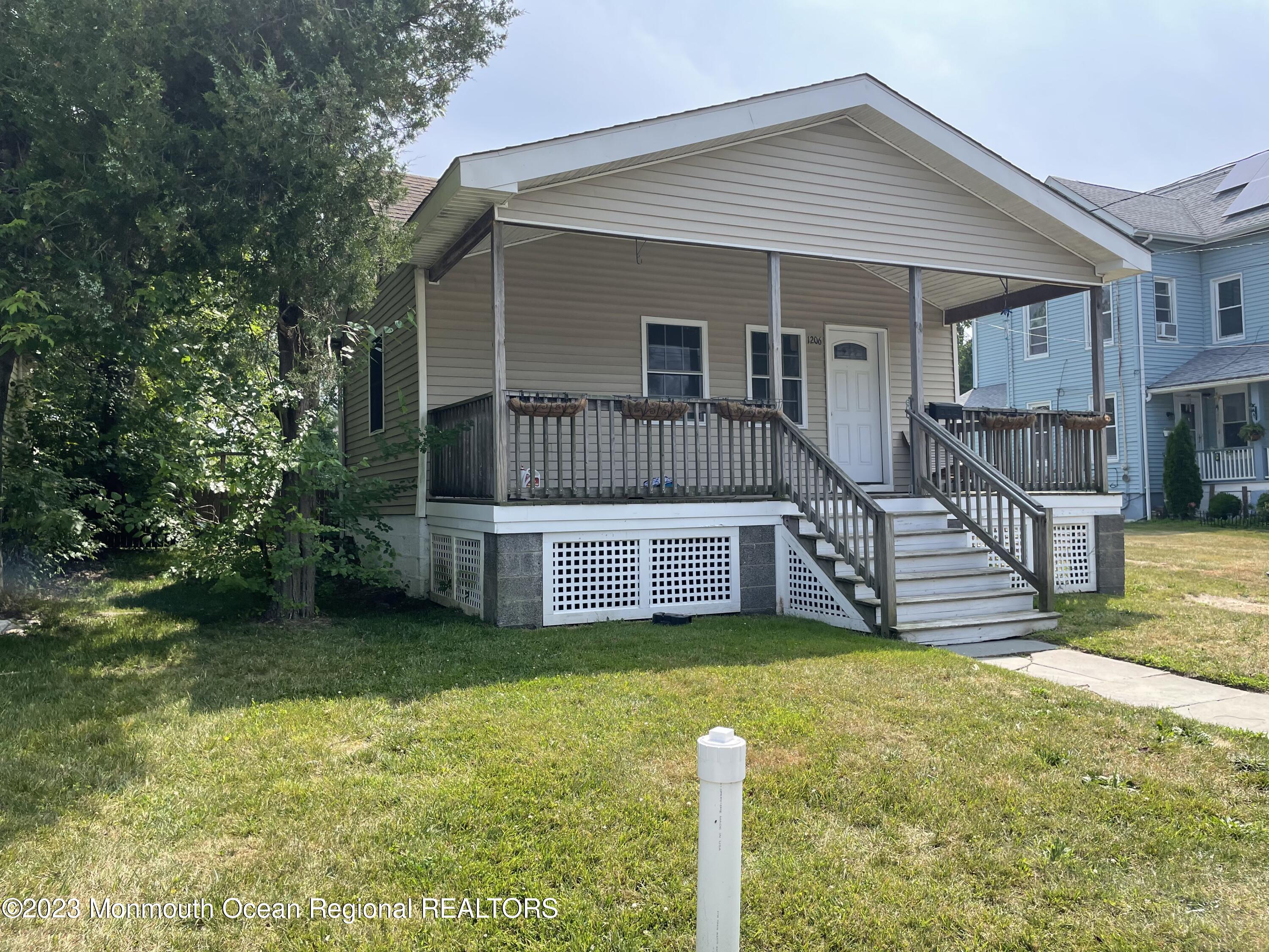 a view of a house with a wooden deck and a yard