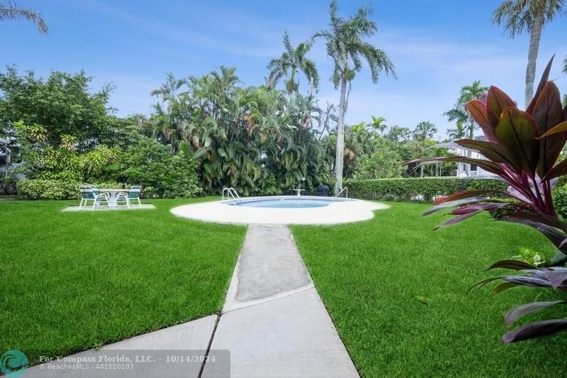 a view of a fountain in front of a house with a big yard