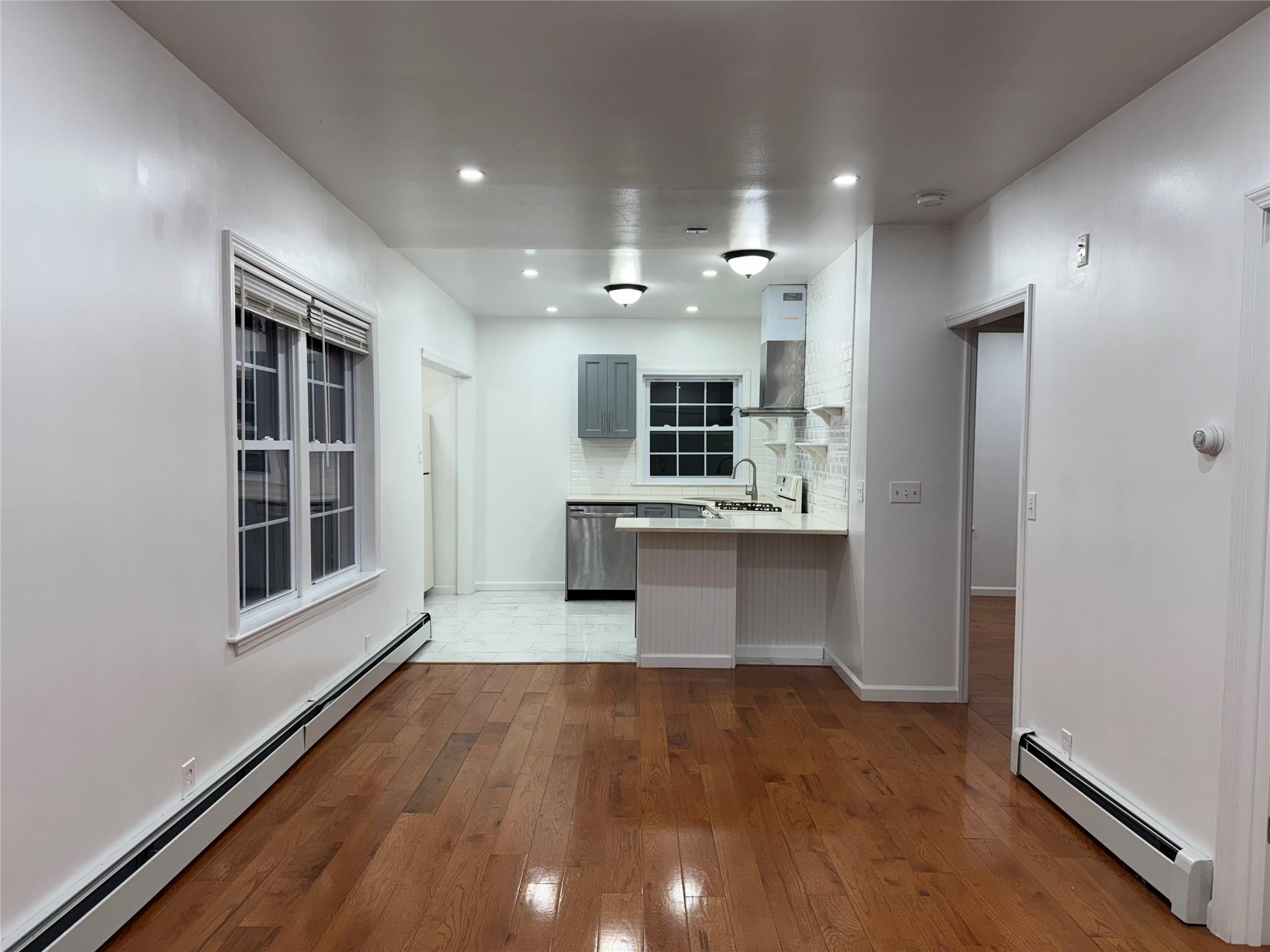 a large kitchen with a large window and stainless steel appliances