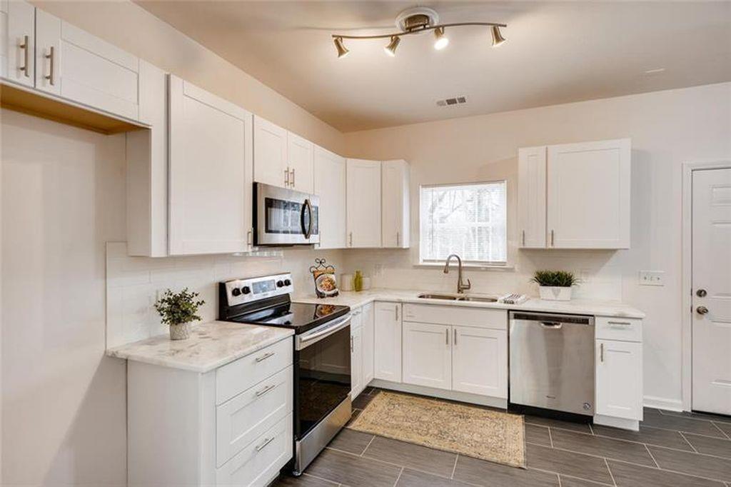 a kitchen with stainless steel appliances granite countertop a sink a stove and a refrigerator