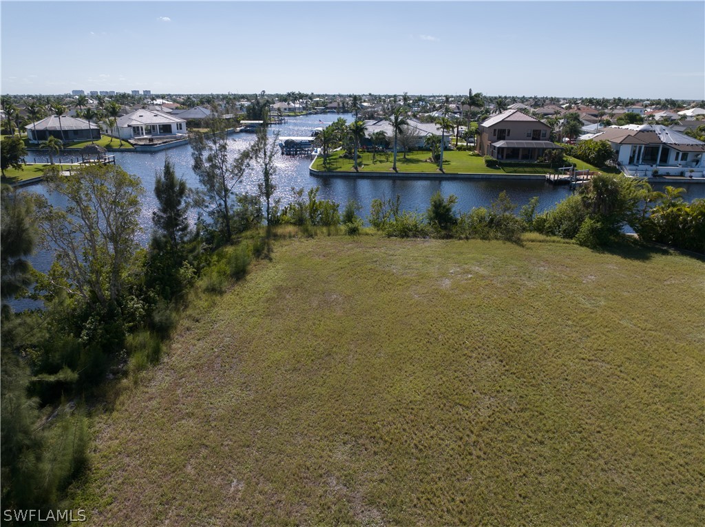 an aerial view of ocean and residential houses with outdoor space