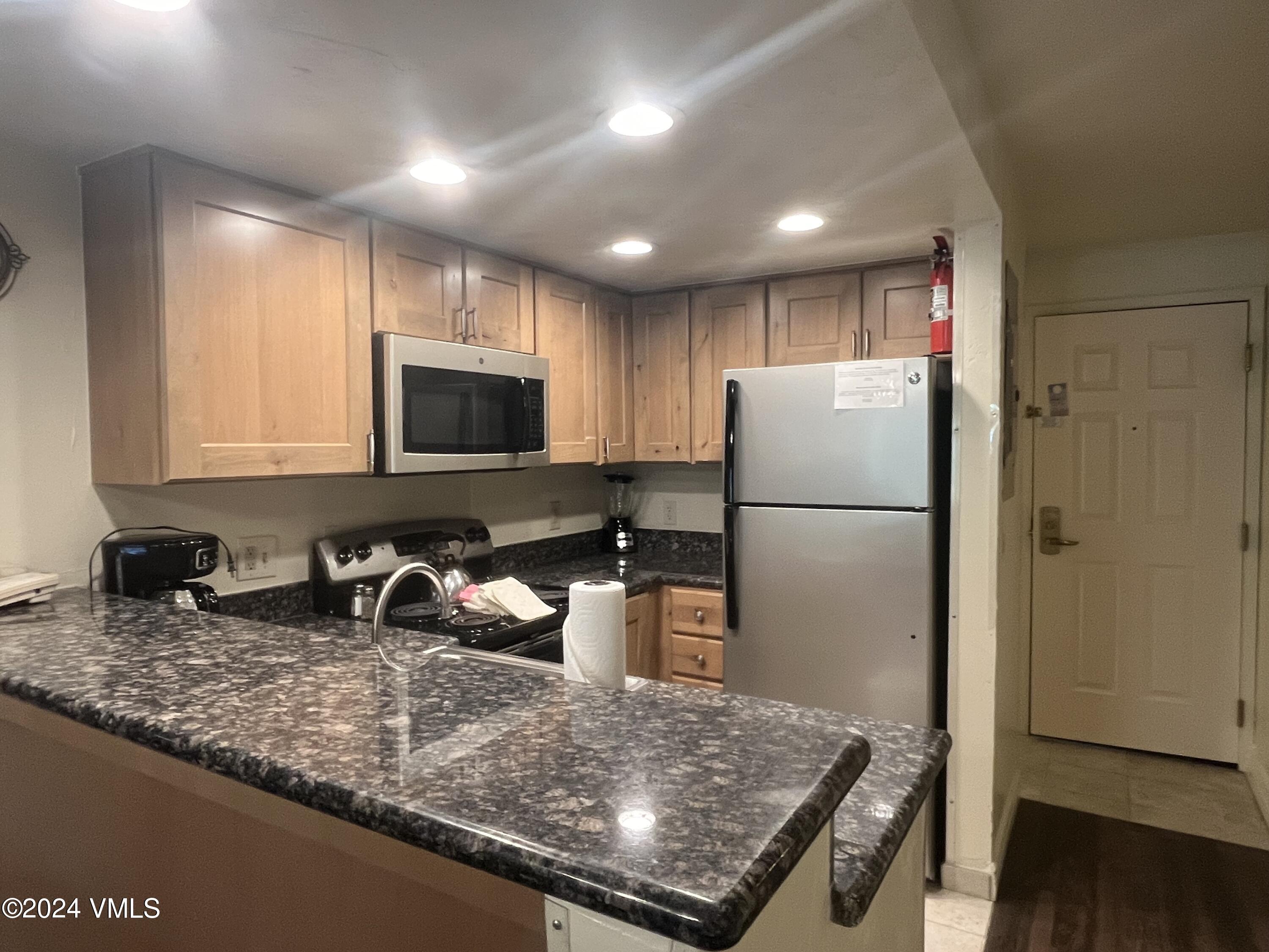 a kitchen with refrigerator and window