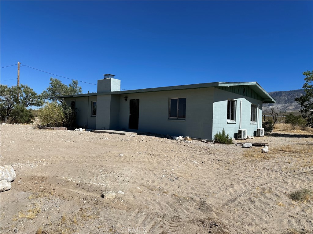 a front view of a house with a dirt yard