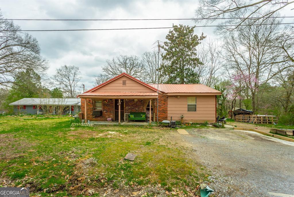 a view of a house with a yard and sitting area