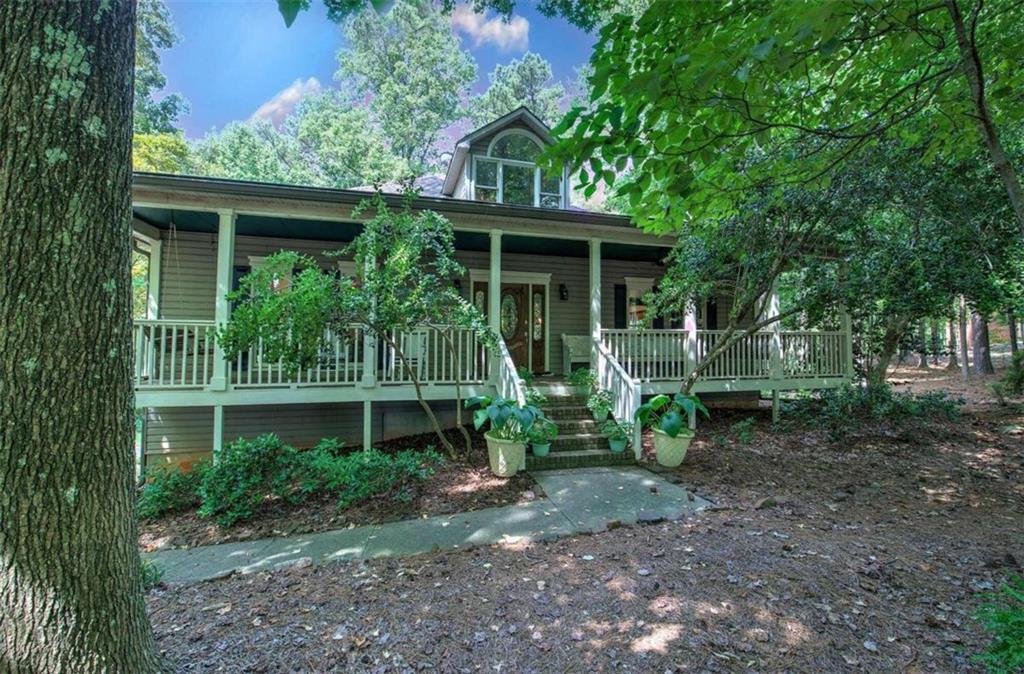 a view of house with a yard and potted plants