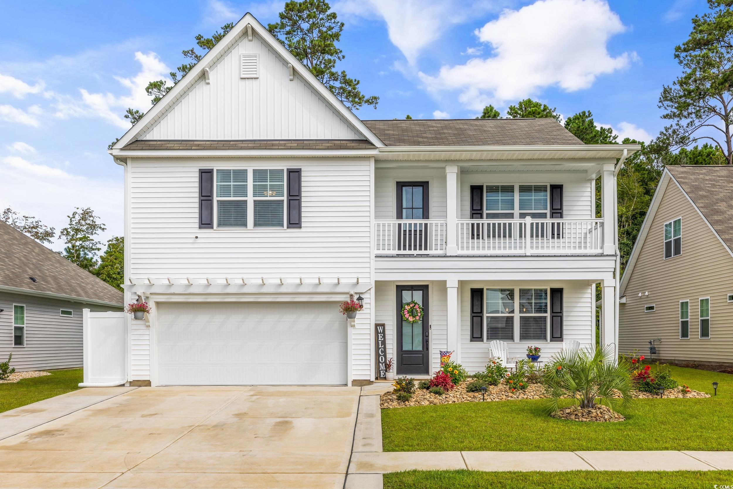 View of front facade featuring a front lawn, a bal