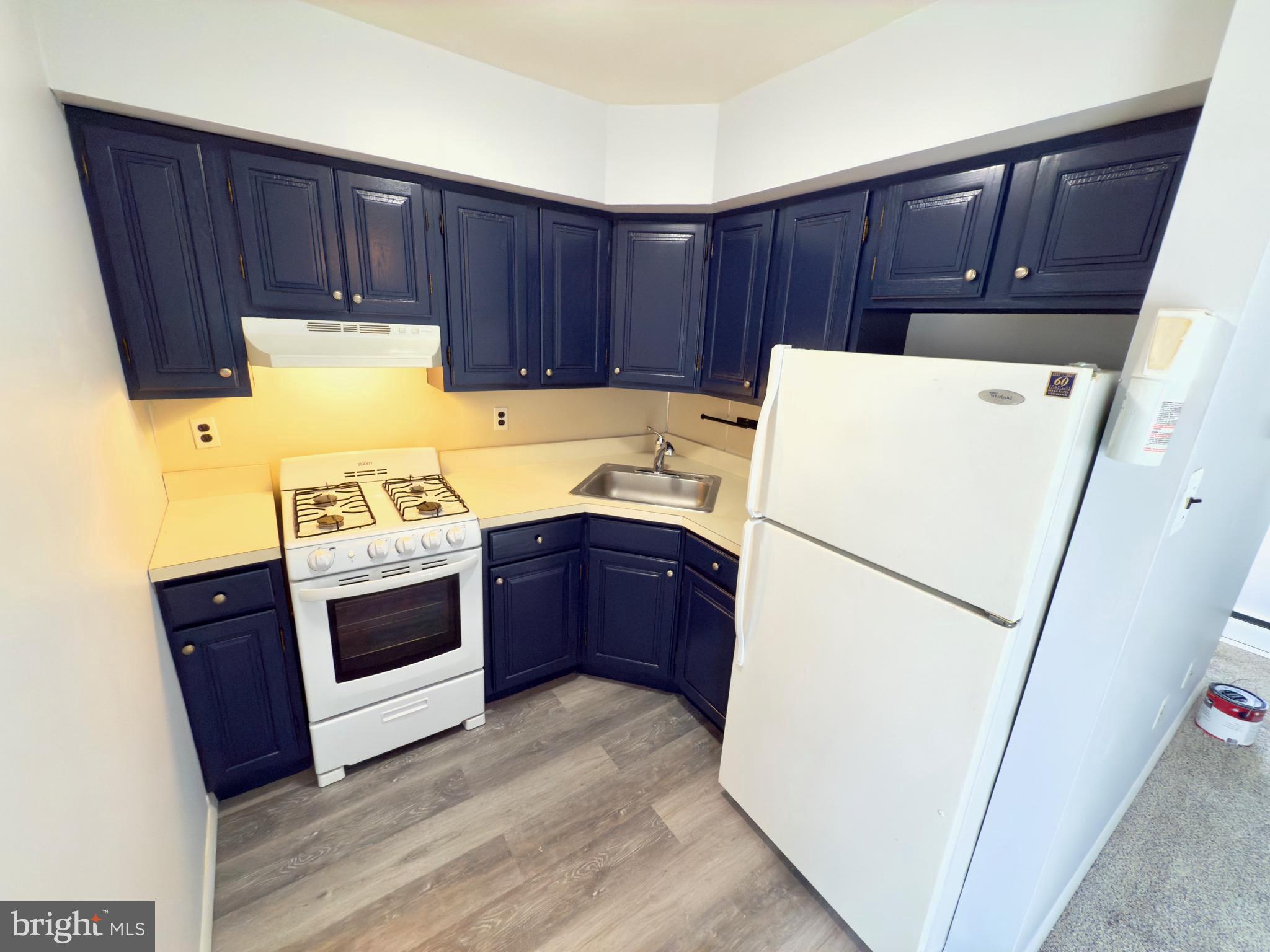 a kitchen with sink a refrigerator and a stove