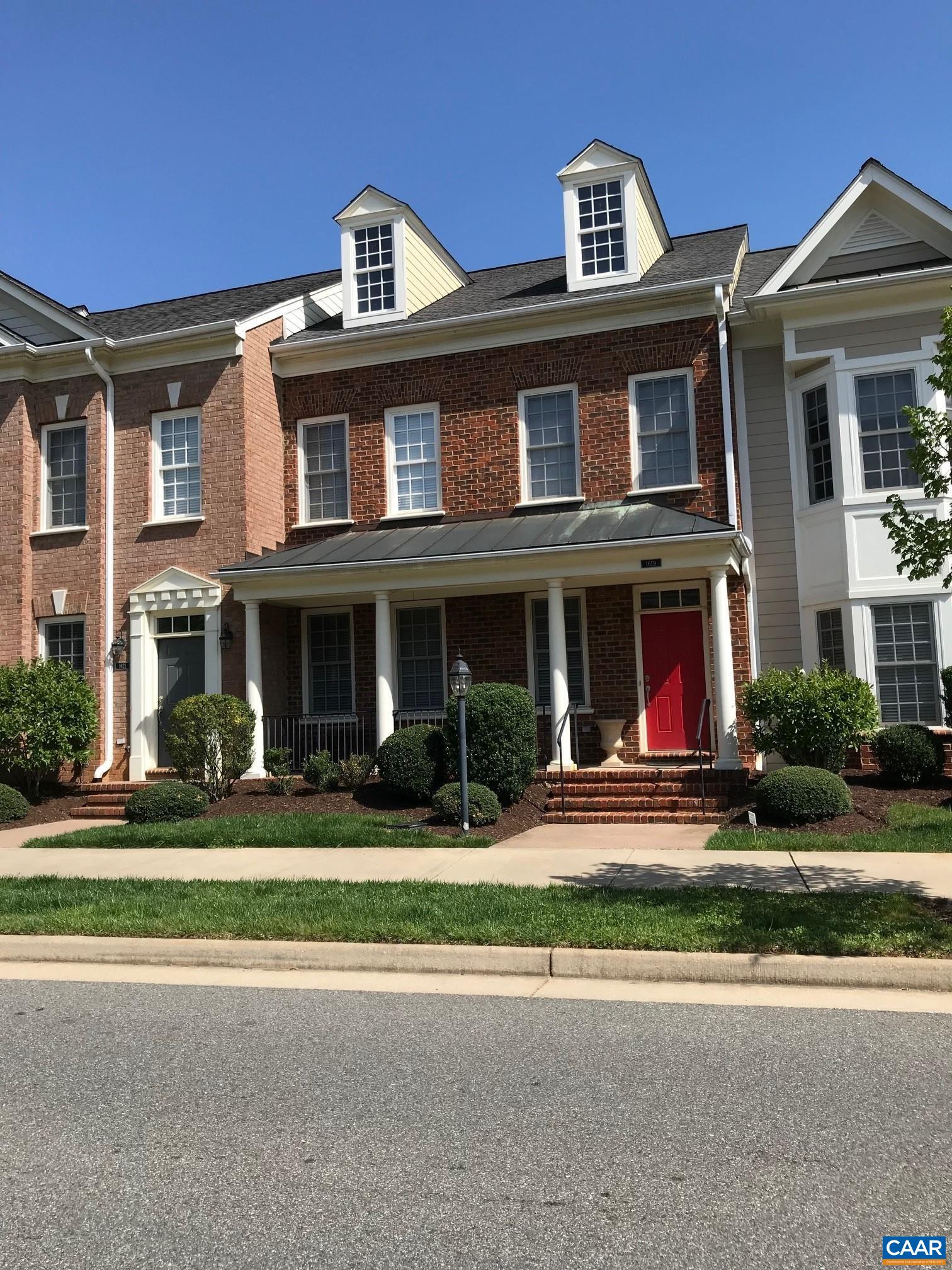 front view of a brick house with a yard