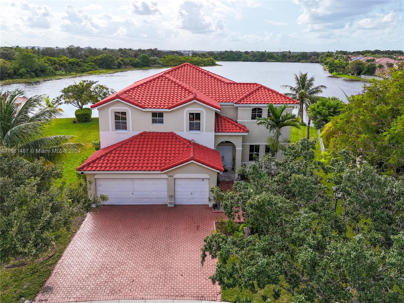 an aerial view of a house with a garden and lake view