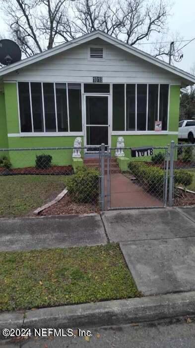 a front view of a house with a yard and potted plants