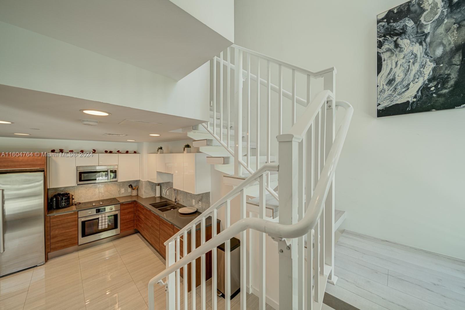 a kitchen with stainless steel appliances kitchen island granite countertop a refrigerator and a stove top oven