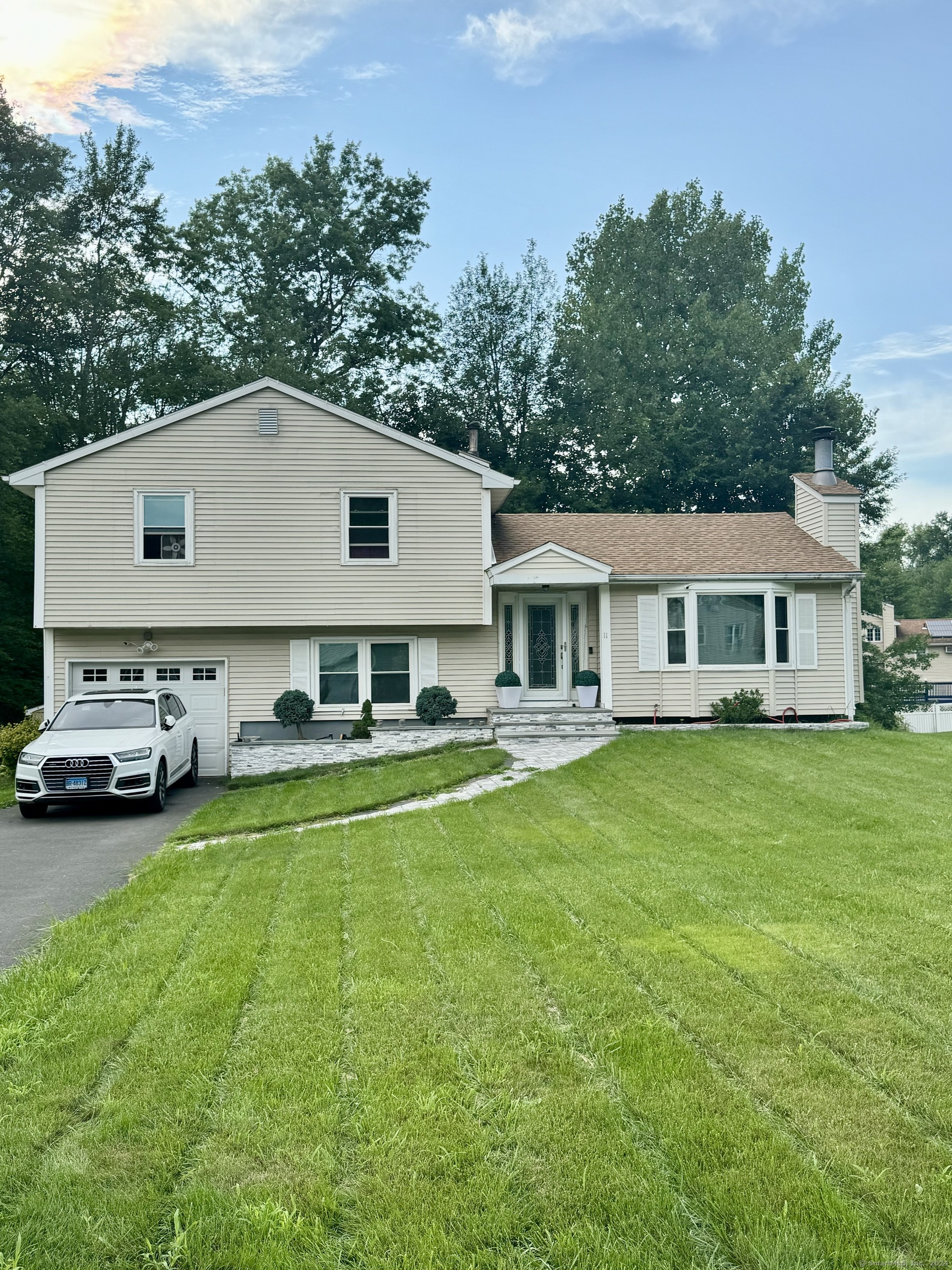 a front view of a house with a garden and yard