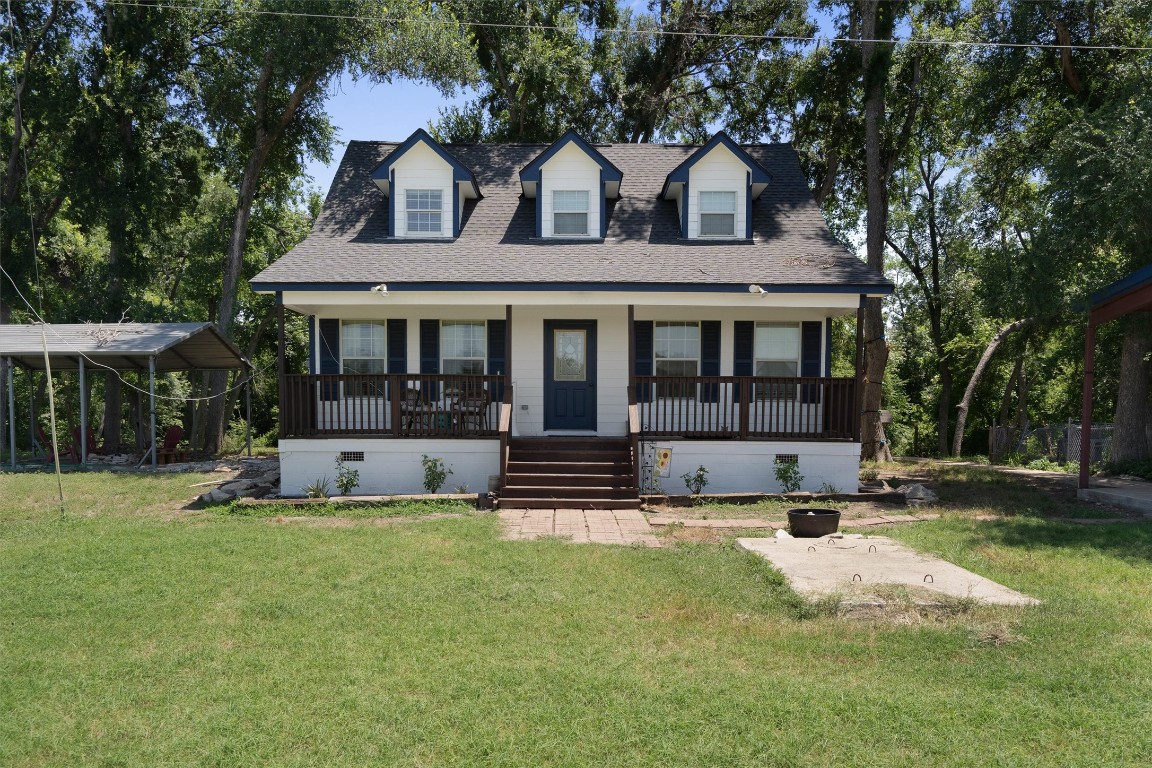 a view of house with a yard and sitting area