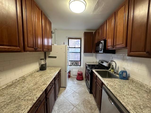 a kitchen with granite countertop stainless steel appliances window a sink and a counter space