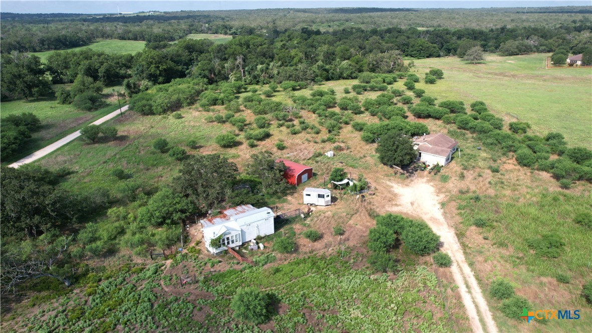 an aerial view of green landscape with trees houses and lake view