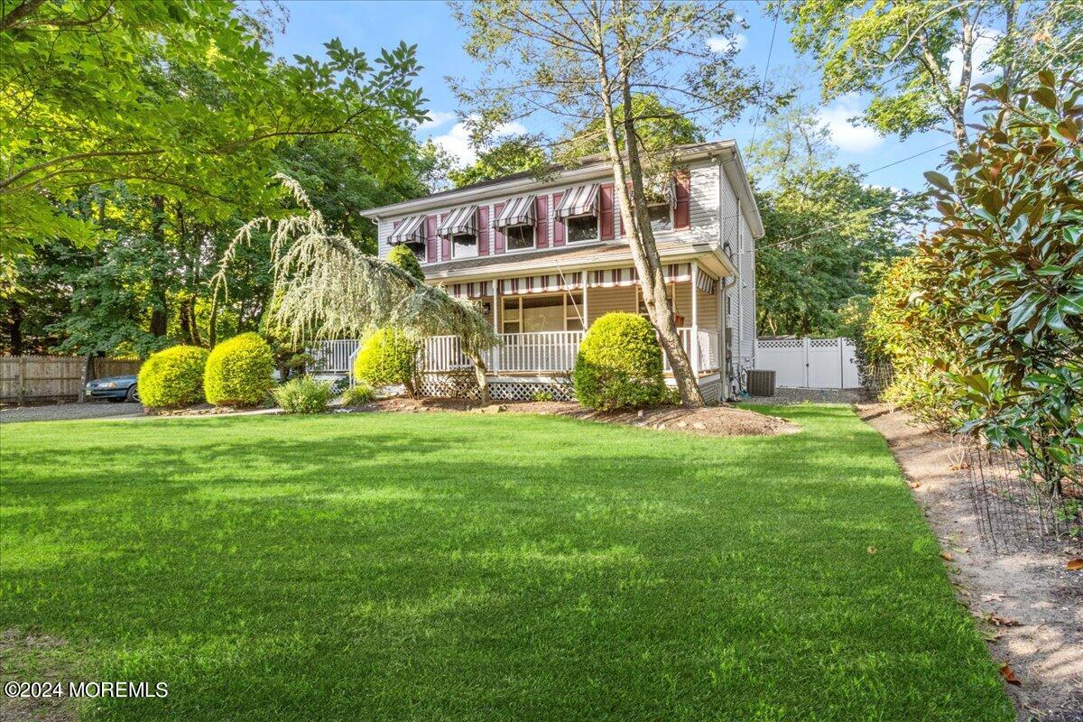 a view of a house with a backyard and a tree