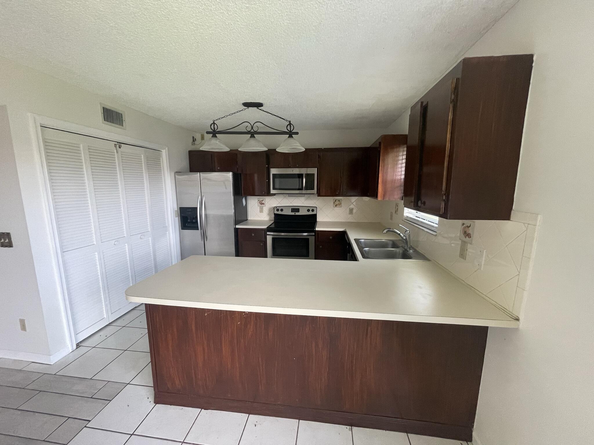 a view of kitchen with stainless steel appliances a refrigerator and a stove top oven