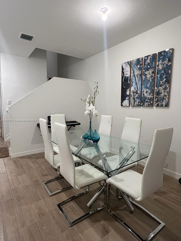 a dining room with furniture and wooden floor