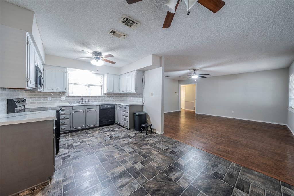 a kitchen with a refrigerator a sink and dishwasher a oven with white cabinets