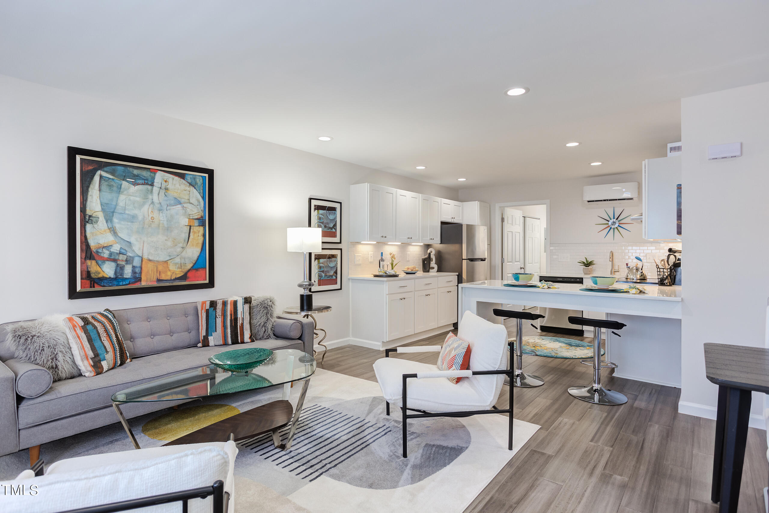 a living room with furniture and a dining table with kitchen view