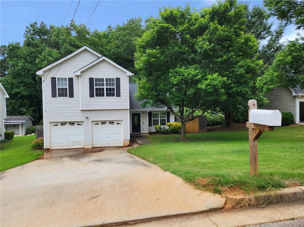 a front view of a house with a yard and trees