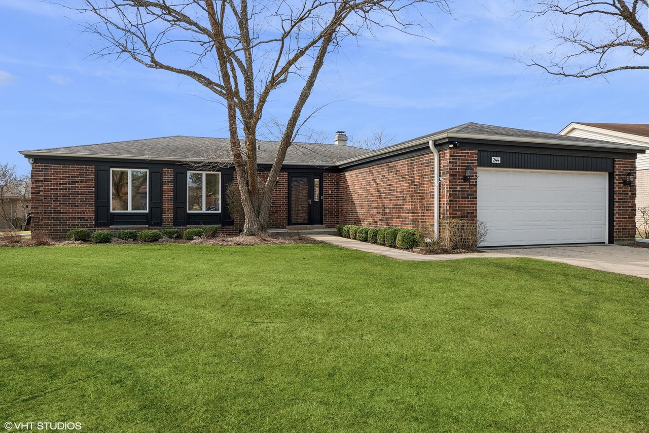 a front view of house with yard and green space