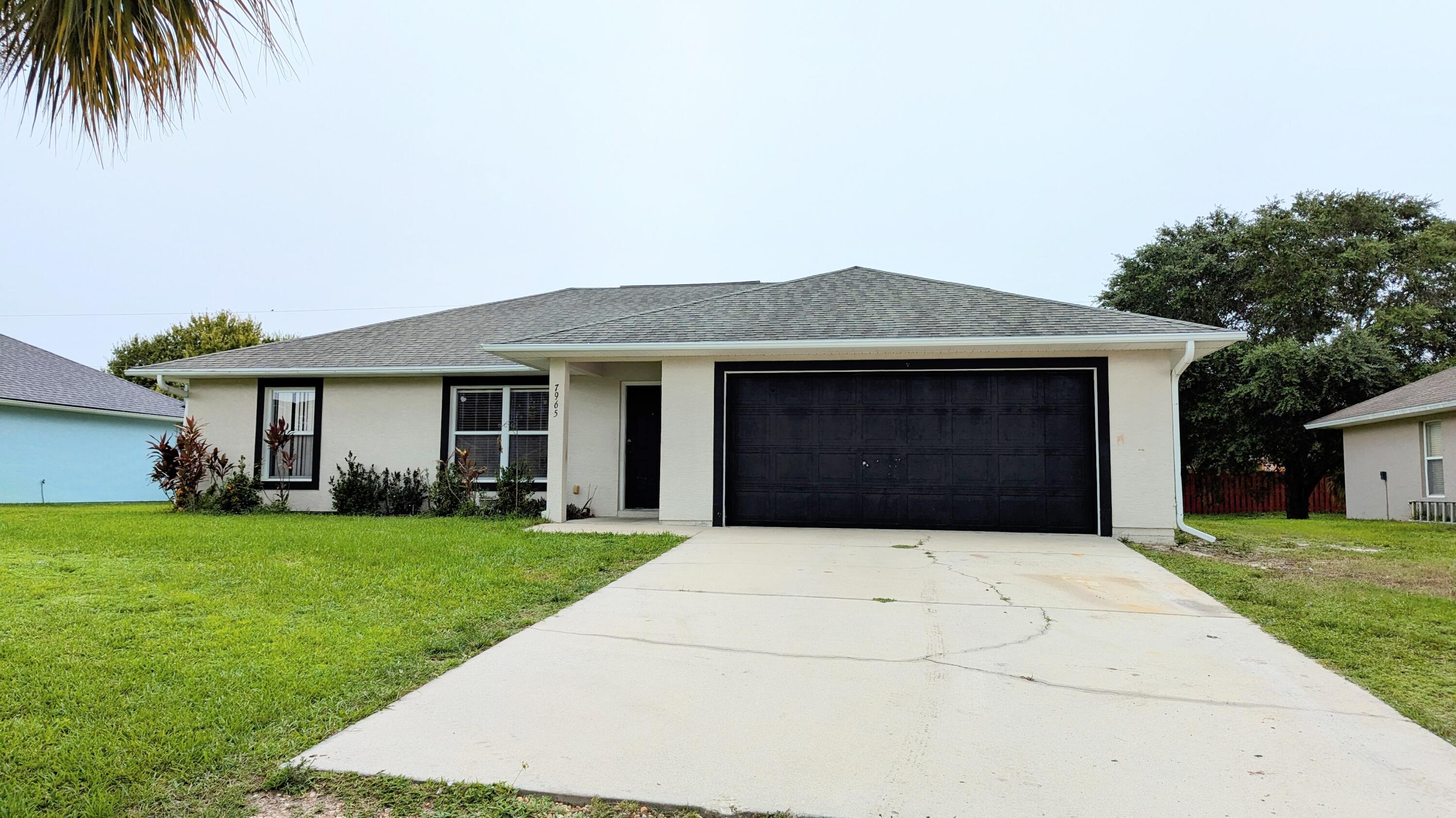 a front view of a house with a garden and yard