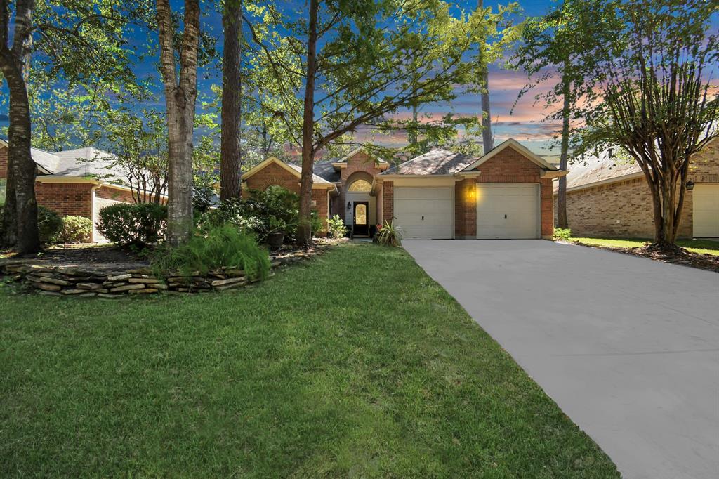 a front view of a house with a garden and trees