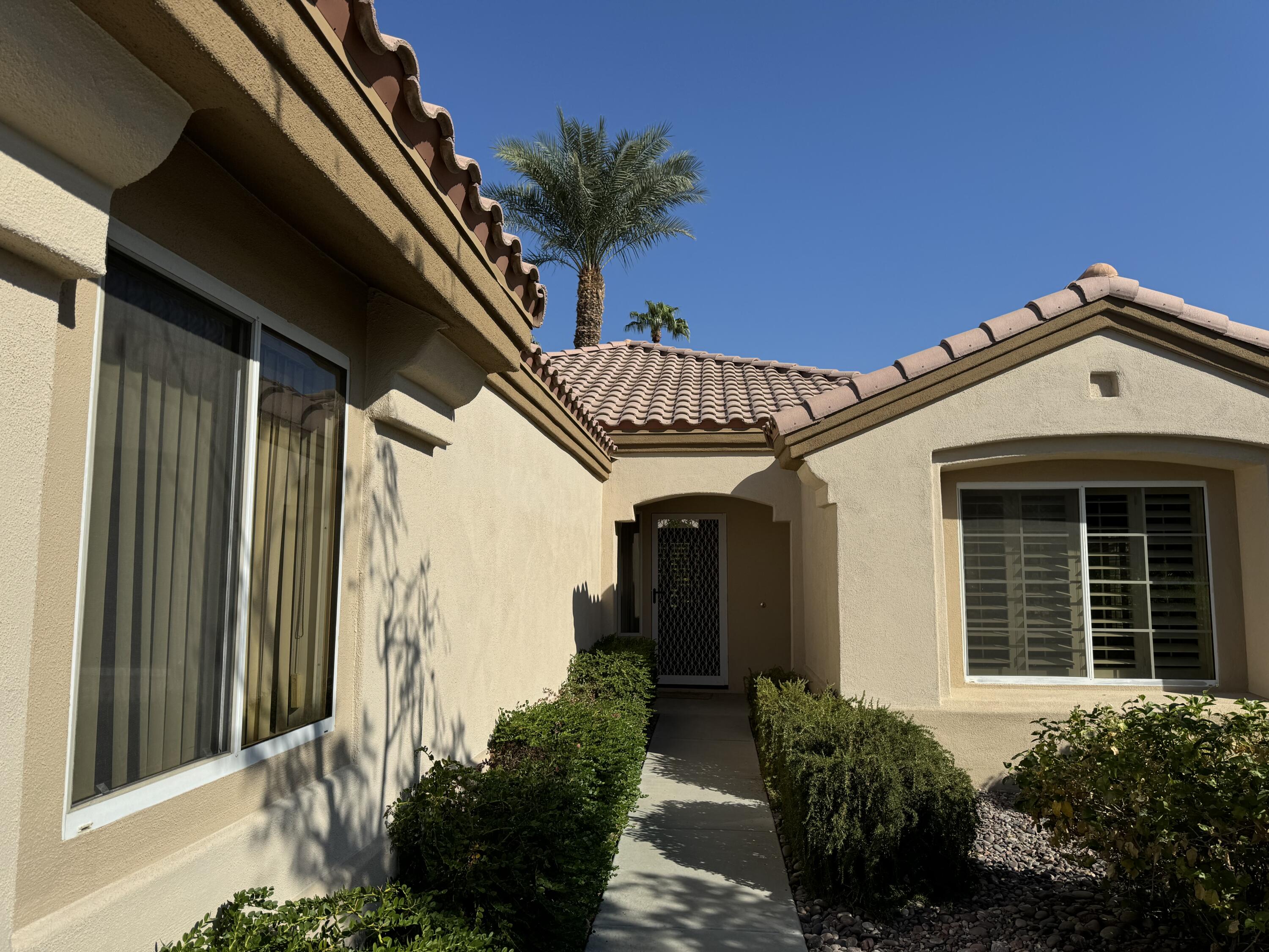 a front view of a house with a garden