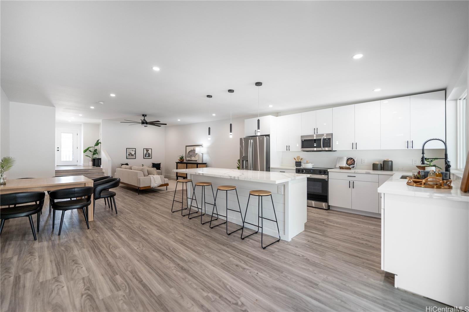 a kitchen with white cabinets and wooden floor