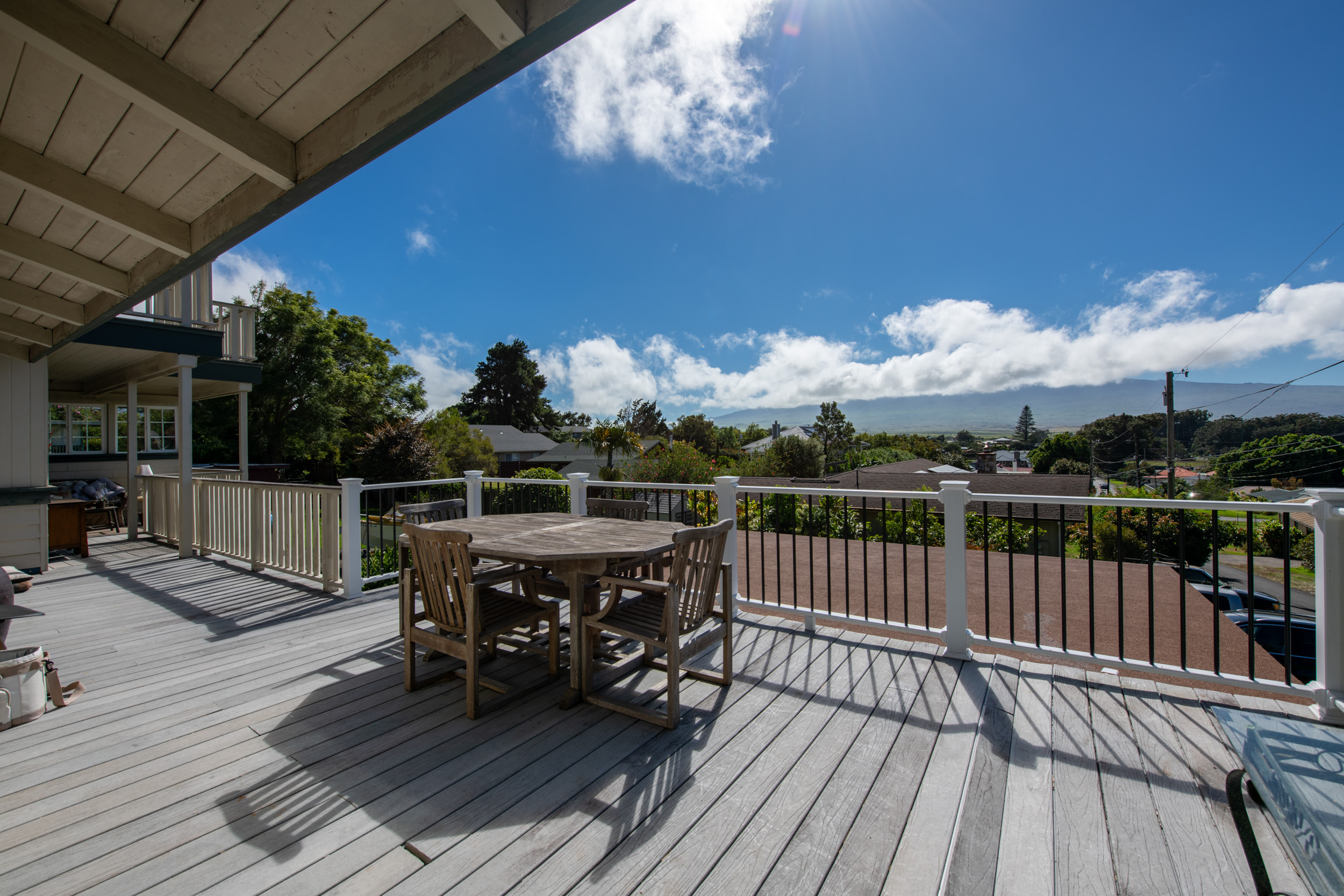 a view of a roof deck with table and chairs with wooden floor and fence