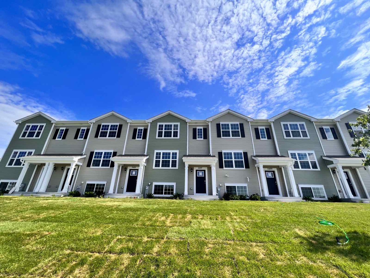 a front view of a residential apartment building with a yard