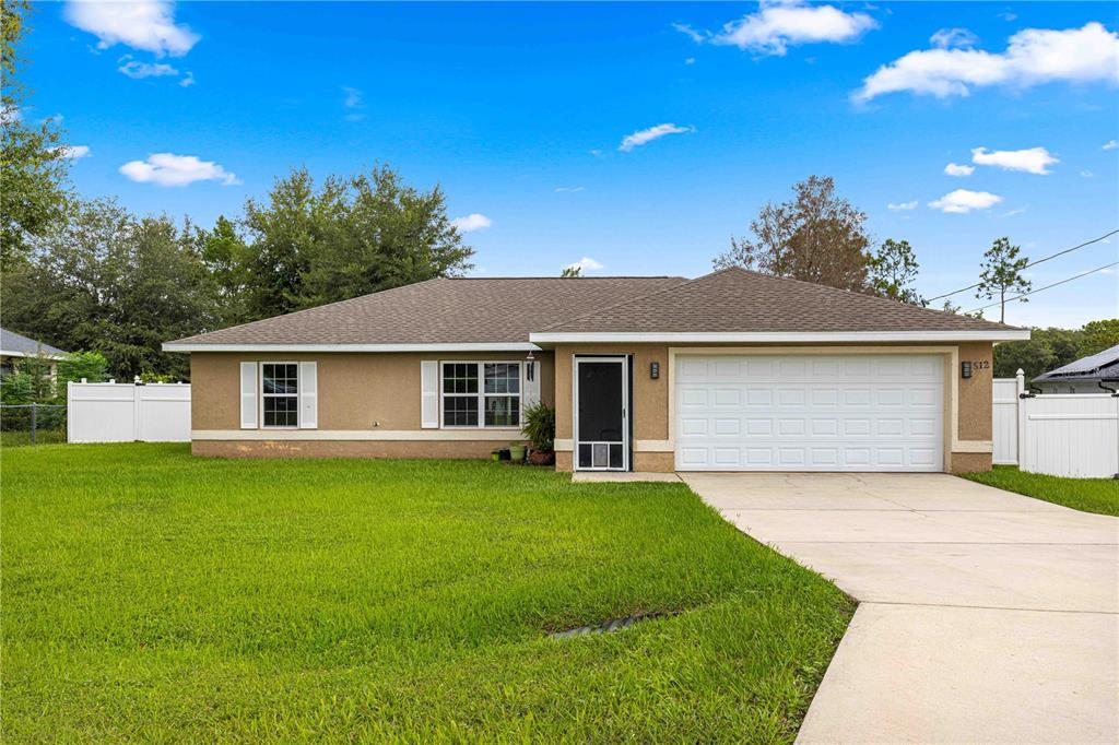 a front view of a house with a garden and yard