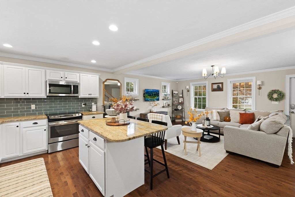 a open kitchen with stainless steel appliances granite countertop a lot of counter space and wooden floor