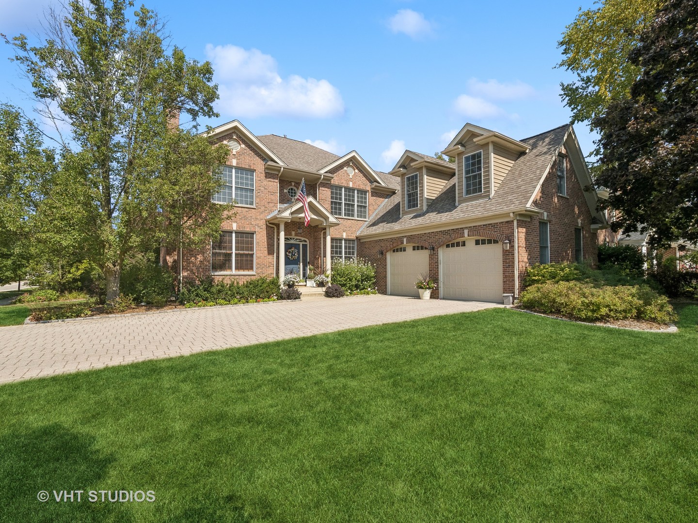 a front view of a house with a garden and yard