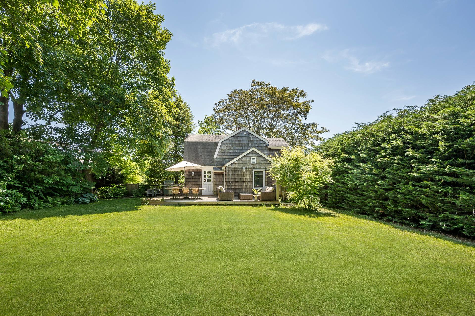 a front view of a house with a yard and trees