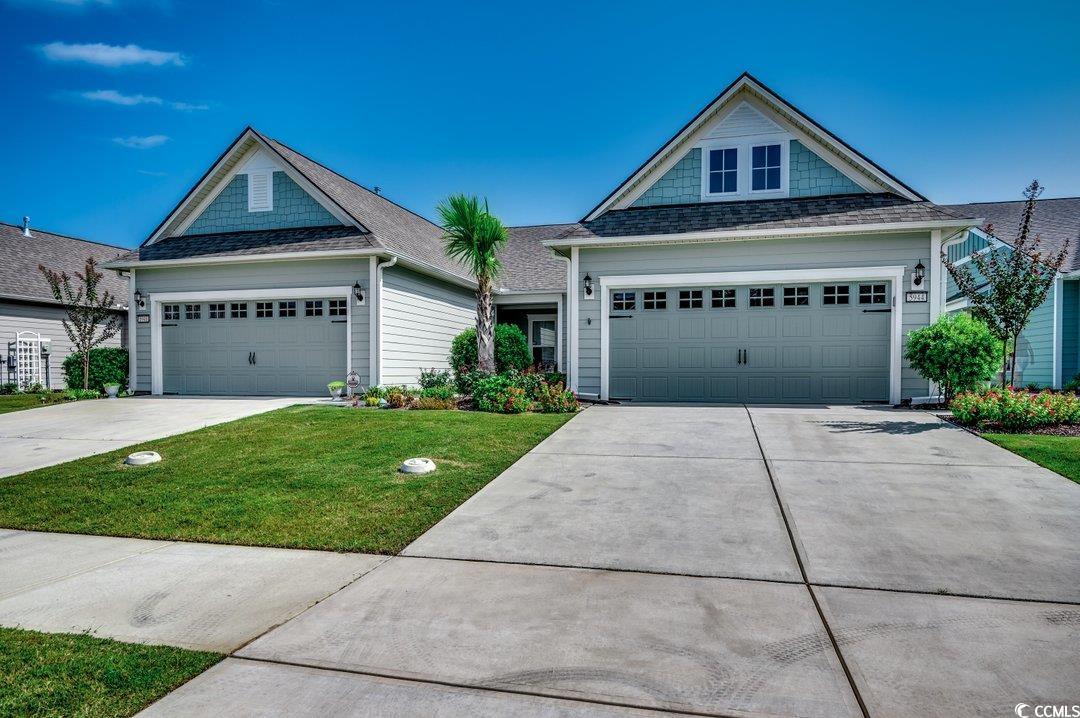 View of front of house with a front lawn and a gar