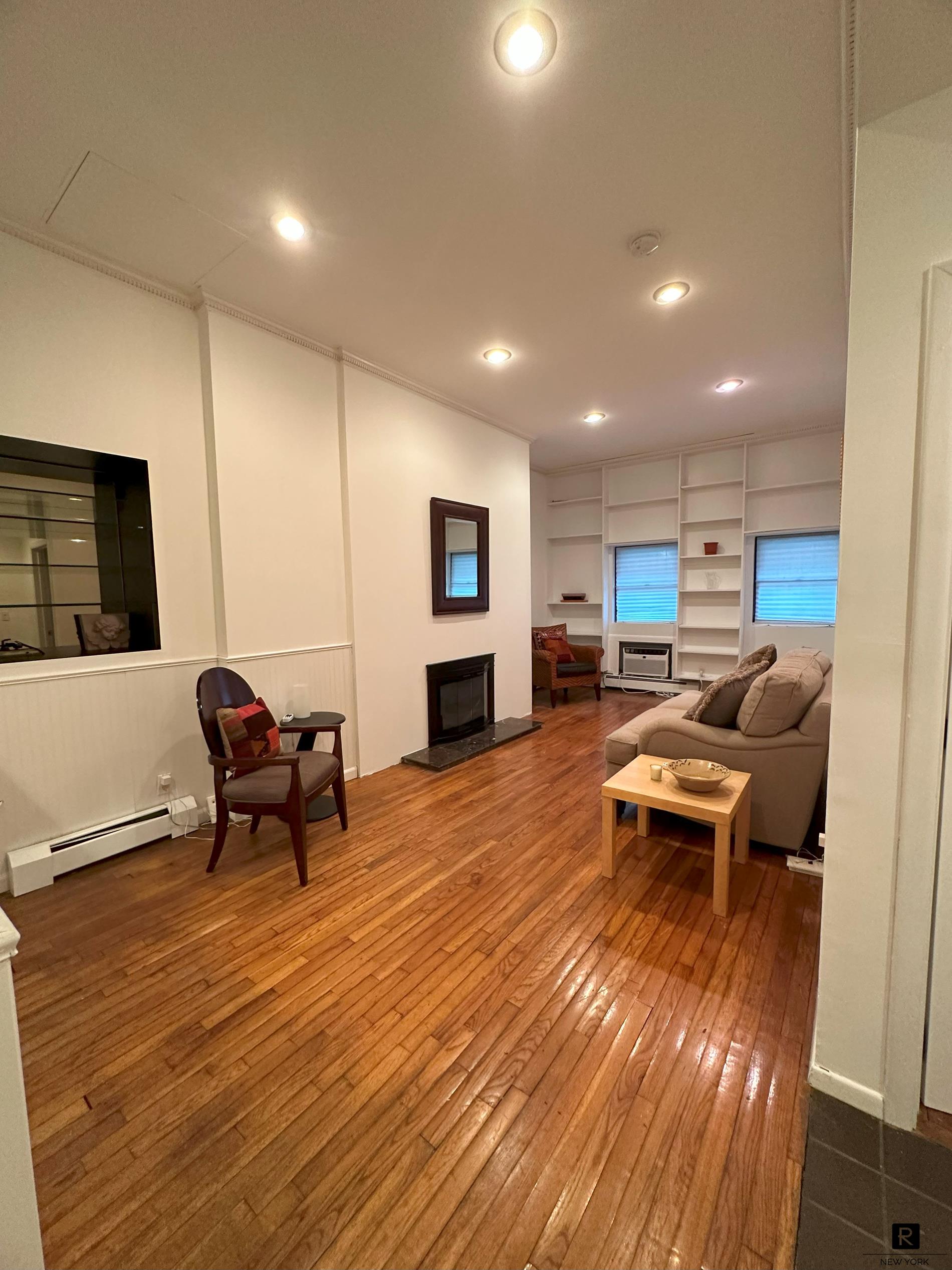 a living room with furniture and a wooden floor