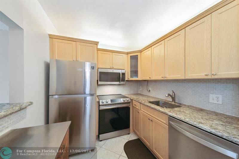 a kitchen with a sink a refrigerator and cabinets